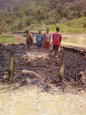 West Papuan children stare at the charred remains of their village after it was burnt down in an Indonesian military sweeping operation. 2010