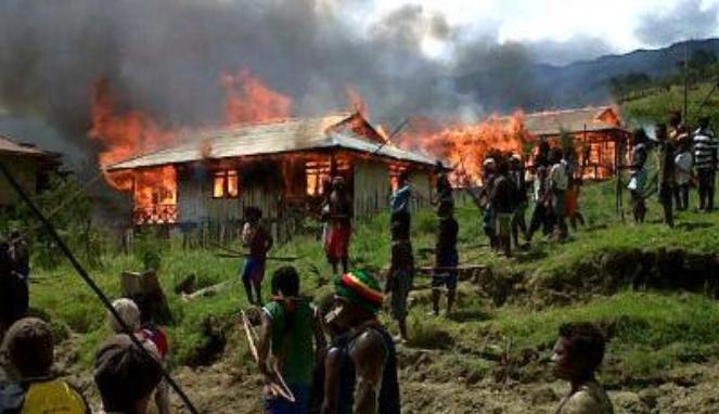 West Papuans return to their village after it is burnt by the Indonesian military