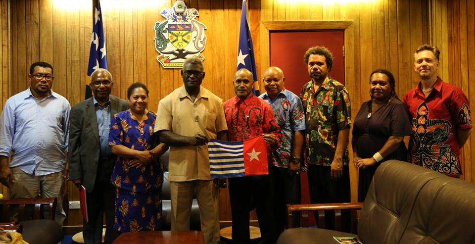 Hon. Manasseh Sogavare, Prime Minister of Solomon Islands holding the West Papuan flag with West Papuan Independence Leader Benny Wenda and standing with other delegates of the United Liberation Movement for West Papua (ULMWP)