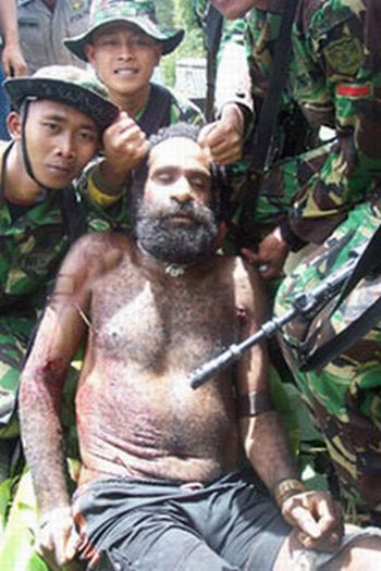 Indonesian soldiers pose grinning with their "trophy photo" corpse of Yustinus Murib, a West Papuan leader they have killed. 2003.
